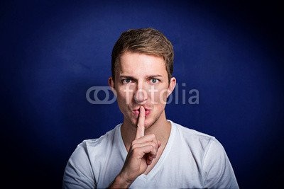 Leinwand-Bild 120 x 80 cm: "junger mann mit finger vor dem mund bittet um ruhe", Bild auf Leinwand
