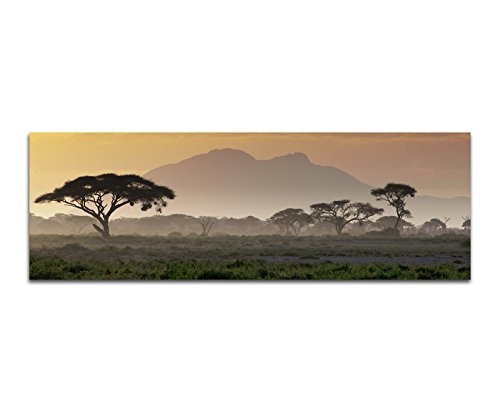 Wandbild auf Leinwand als Panorama in 120x40 cm Afrika bei Sonnenuntergang! Afrikanische Savanne mit Baum und Berge.Serengeti mit Graslandschaft.