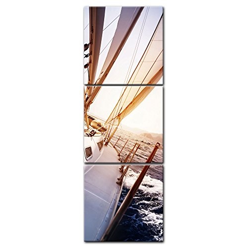 Wandbild - Yacht auf See - Bild auf Leinwand - 60x180 cm dreiteilig - Leinwandbilder - Urlaub, Sonne & Meer - Boot im Sonnenaufgang - Blick vom Deck