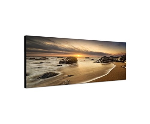 Paul Sinus Art Panoramabild auf Leinwand und Keilrahmen 150x50cm Meer Strand Steine Sonnenaufgang Wolken