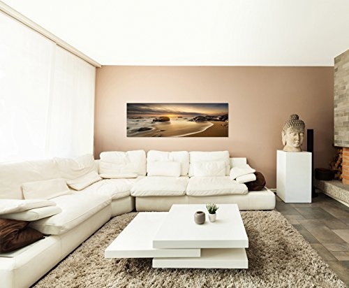 Paul Sinus Art Panoramabild auf Leinwand und Keilrahmen 150x50cm Meer Strand Steine Sonnenaufgang Wolken